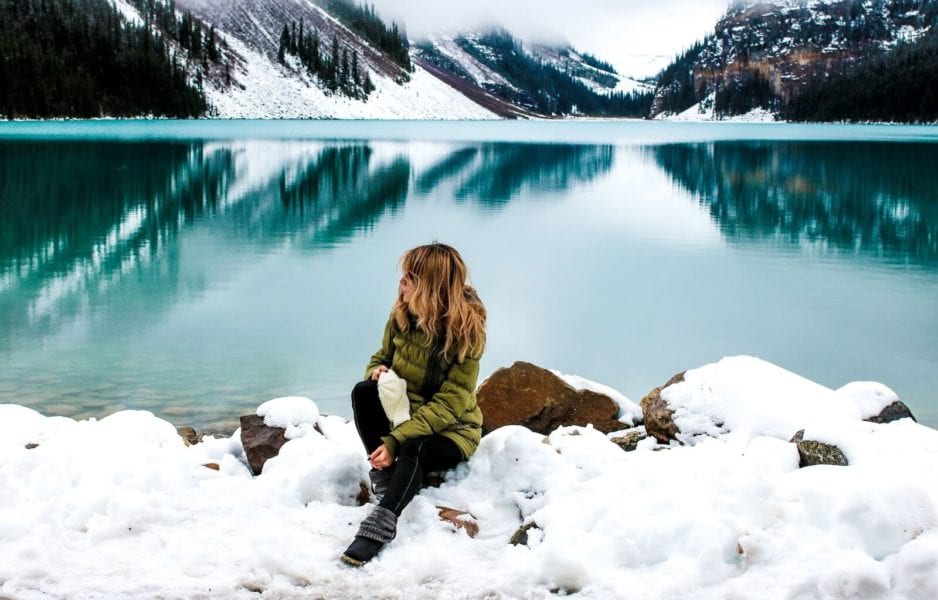girl sitting in the snow alone - benefits of travelling alone